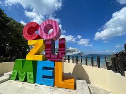 Iconic colorful letters at Cozumel with turquoise waters and white sandy beach in the background.